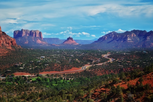 green trees and mountains under blue sky during daytime