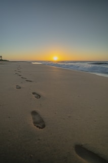 sea waves crashing on shore during sunset