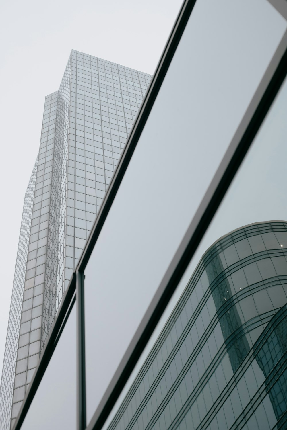 a tall building is reflected in the windows of another building