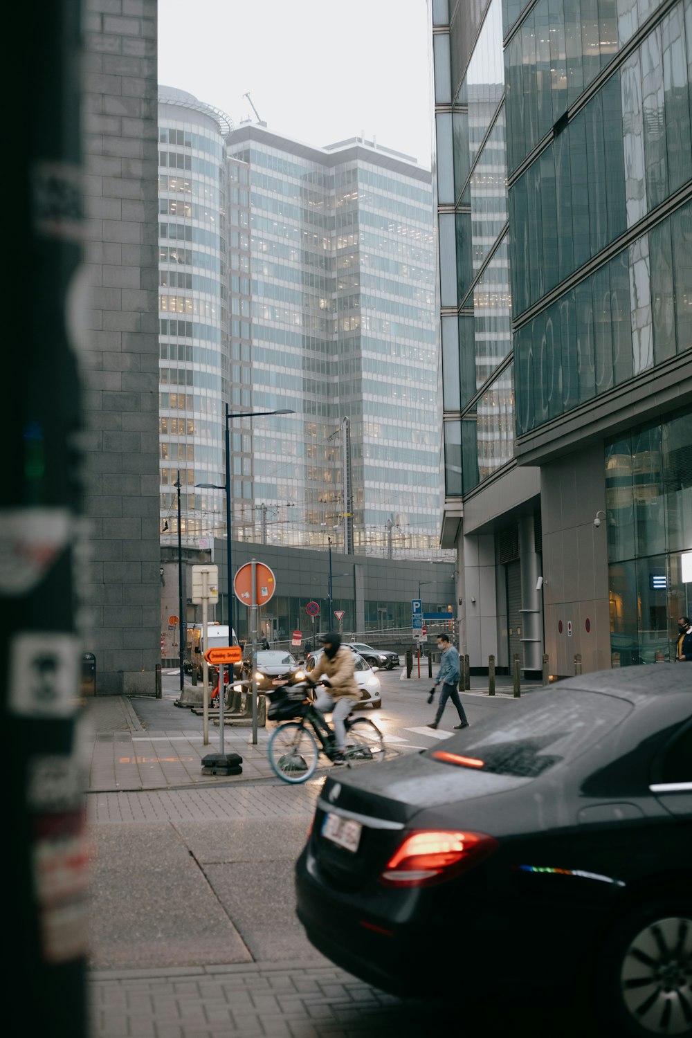 people riding motorcycle on road near high rise buildings during daytime