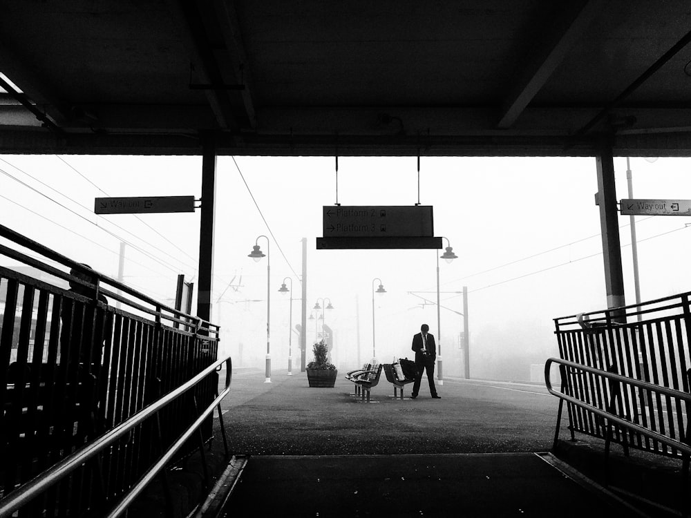 grayscale photo of 2 people walking on sidewalk