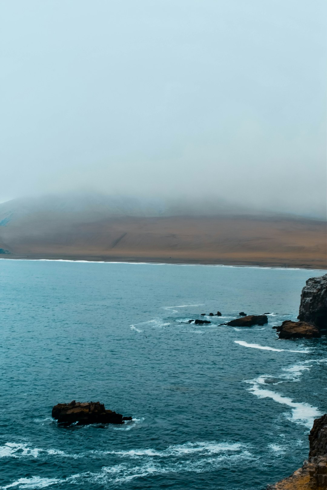 body of water near mountain during daytime