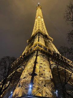 A nighttime view of a completed project illuminated with warm golden lighting highlighting its structure.
