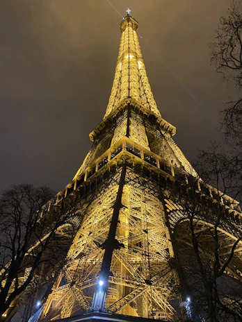 A nighttime view of a completed project illuminated with warm golden lighting highlighting its structure.