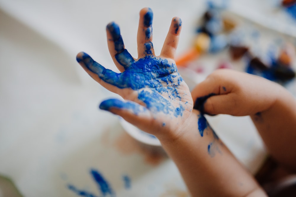 pessoa com tinta azul na mão