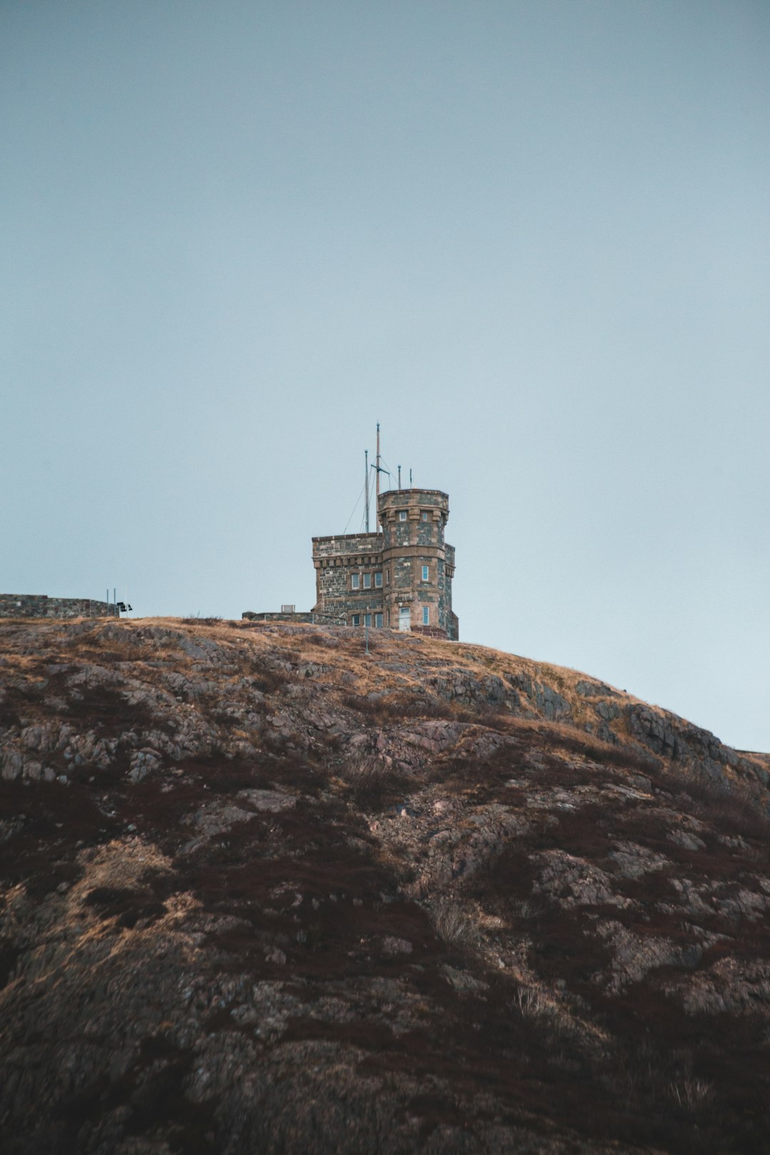 brown concrete building on brown rock formation under blue sky during daytime