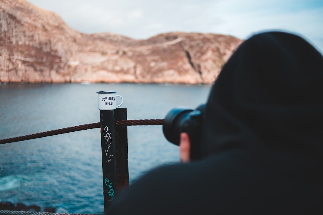 person in black hoodie holding black and white stick