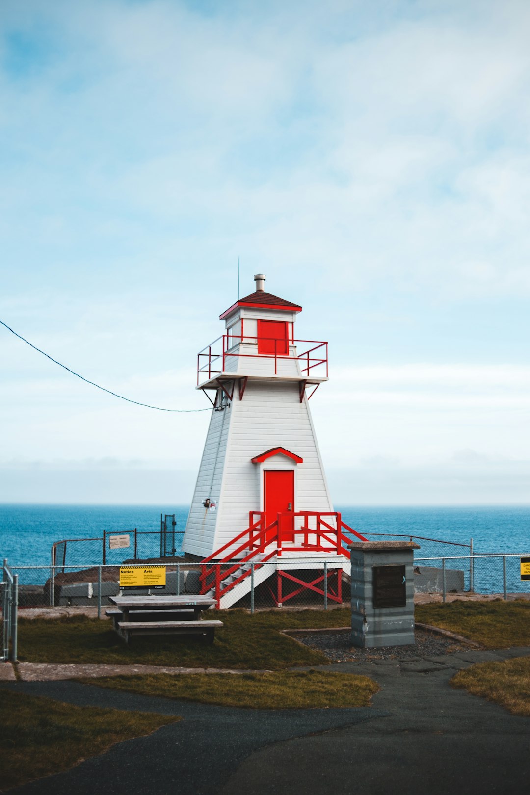 white and red lighthouse near body of water during daytime