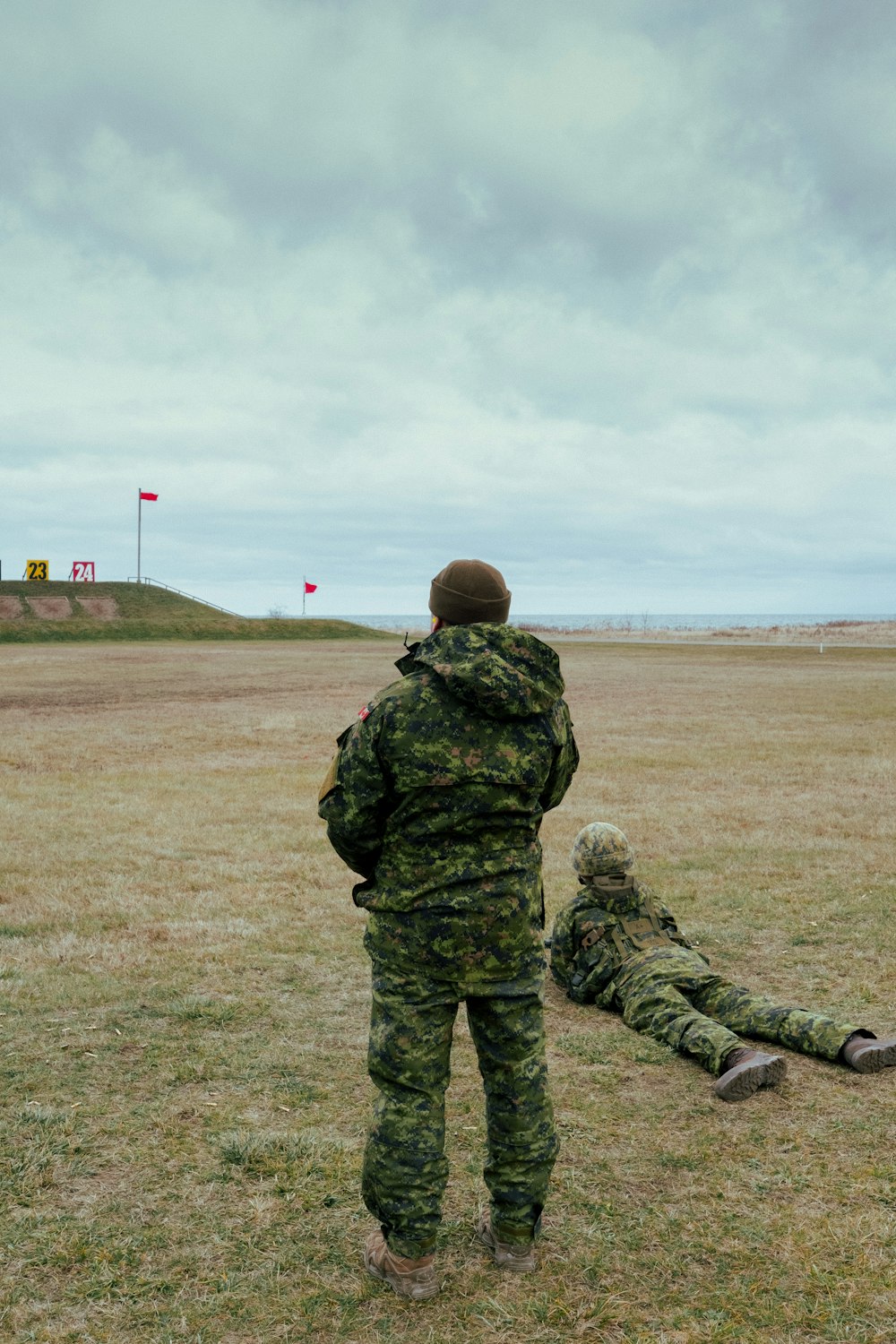 man in green camouflage uniform standing on green grass field during daytime