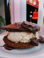 A minimalist shot of an ice cream sandwich with rich Indian ice cream melting slightly between soft bread.