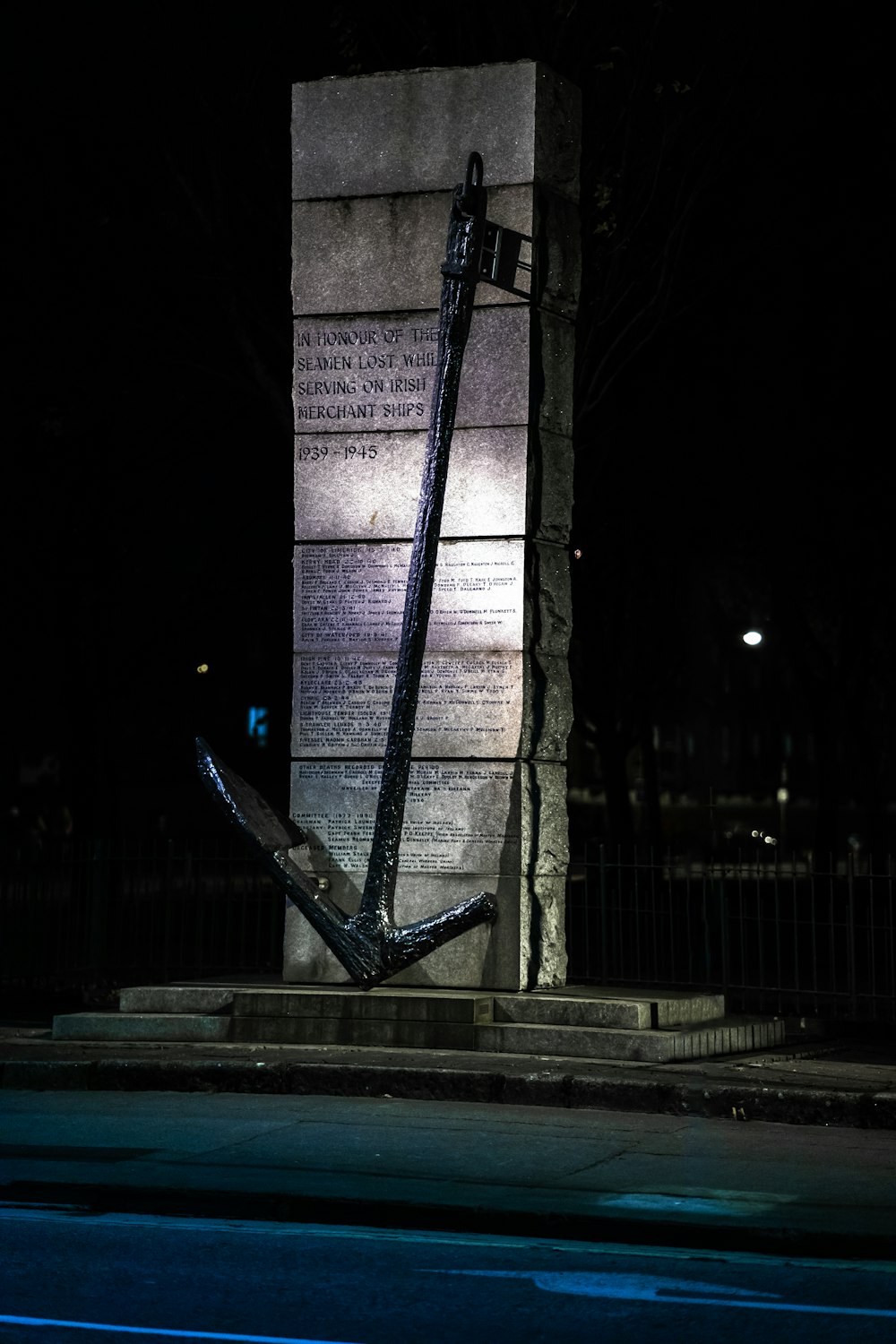 Schwarzer Metallzaun in der Nähe von braunem Betongebäude während der Nacht