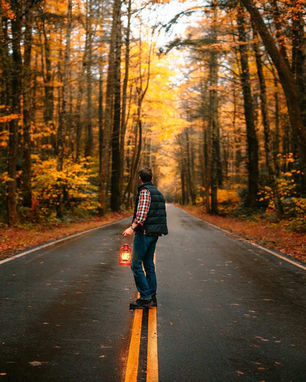 man in black jacket and black pants walking on road during daytime