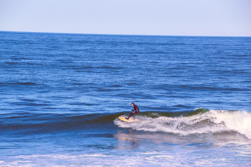 man surfing on sea waves during daytime