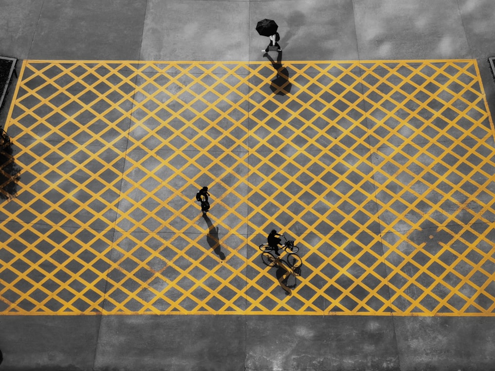 3 men walking on white and blue floor tiles