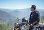 man in blue jacket and black pants riding black motorcycle