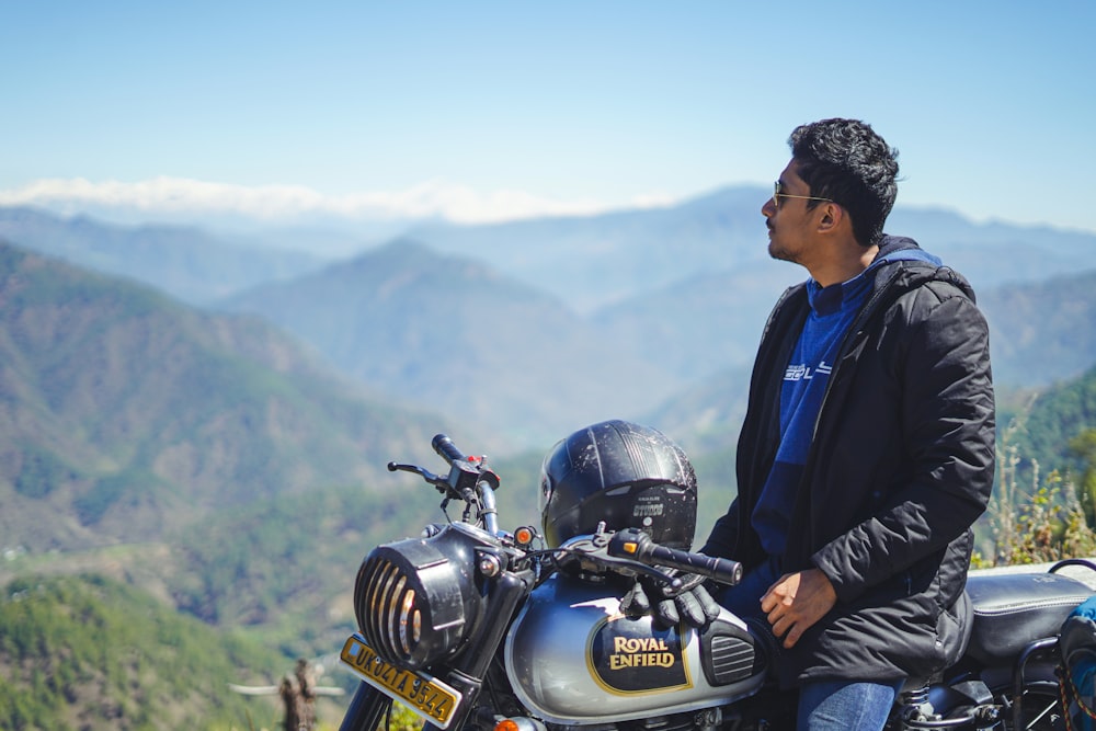 man in blue jacket and black pants riding black motorcycle