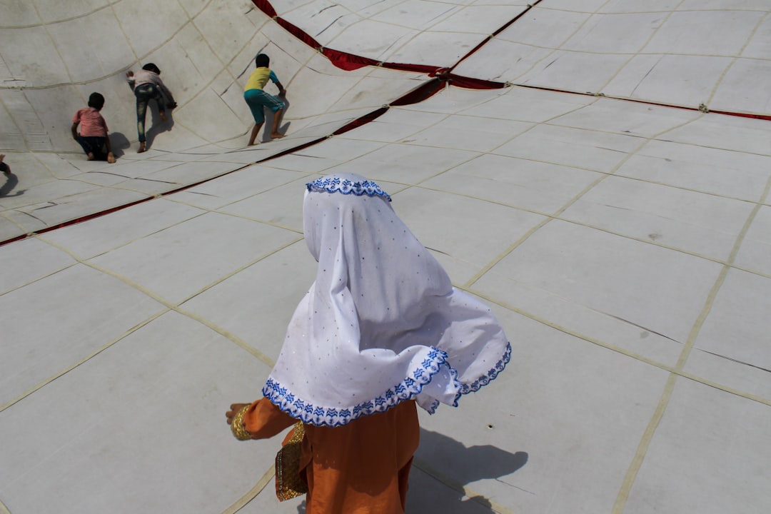 woman in white hijab standing on white floor tiles