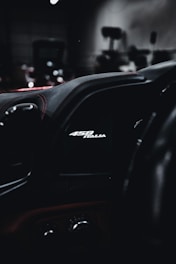 A computer screen displaying vehicle performance software with a sleek black and red interface.