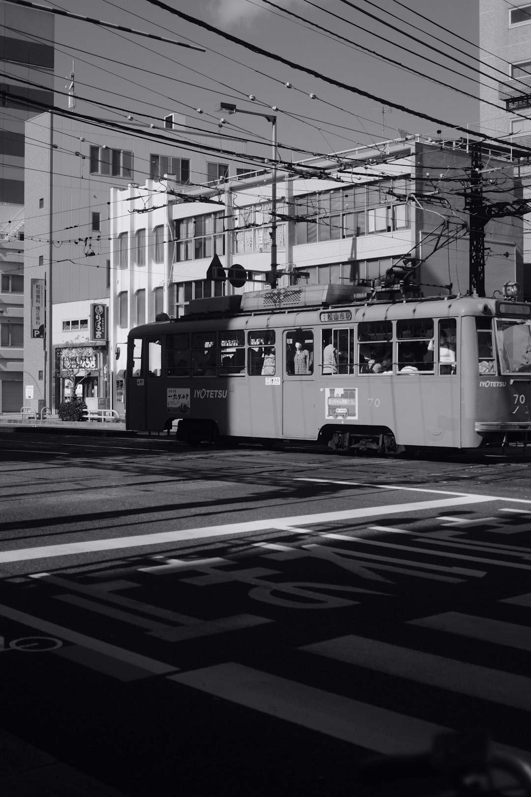 grayscale photo of people riding on tram