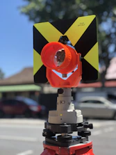 Surveyor using a total station device on a construction site.