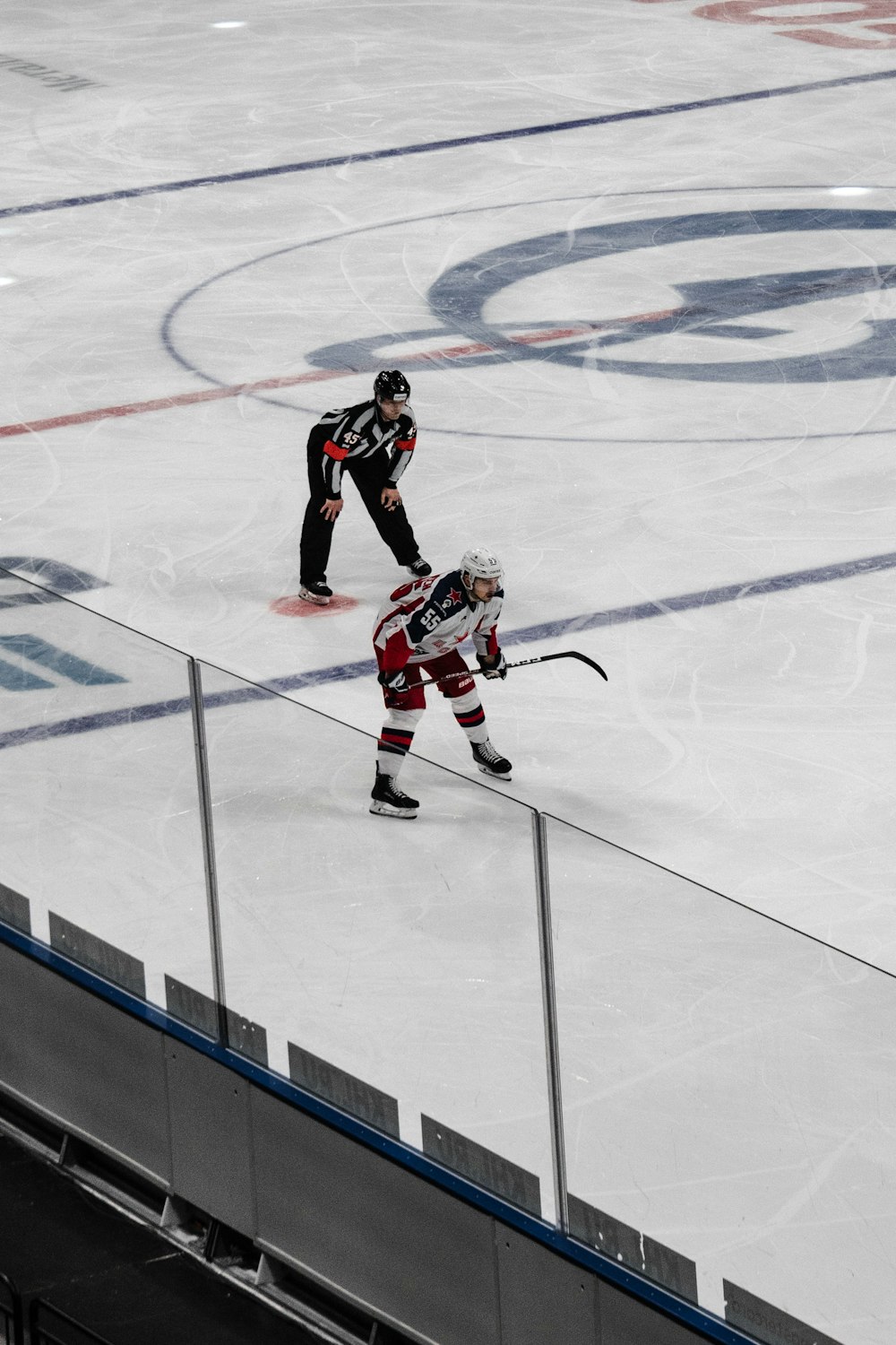 man in black and red ice hockey jersey shirt and black pants playing hockey
