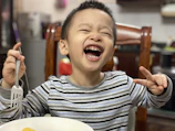 Children proudly displaying their cooking creations with smiles and laughter.