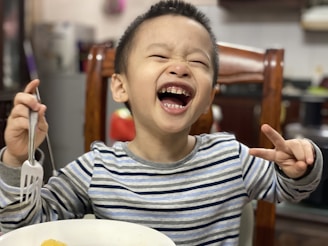 A smiling child using left-handed scissors for the first time.