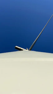 Engineer inspecting wind turbine blades on a clear day.