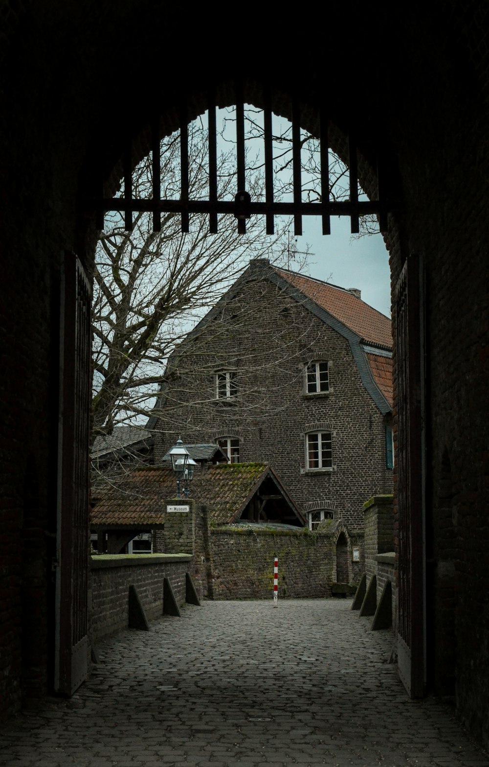 brown brick house near bare trees during daytime