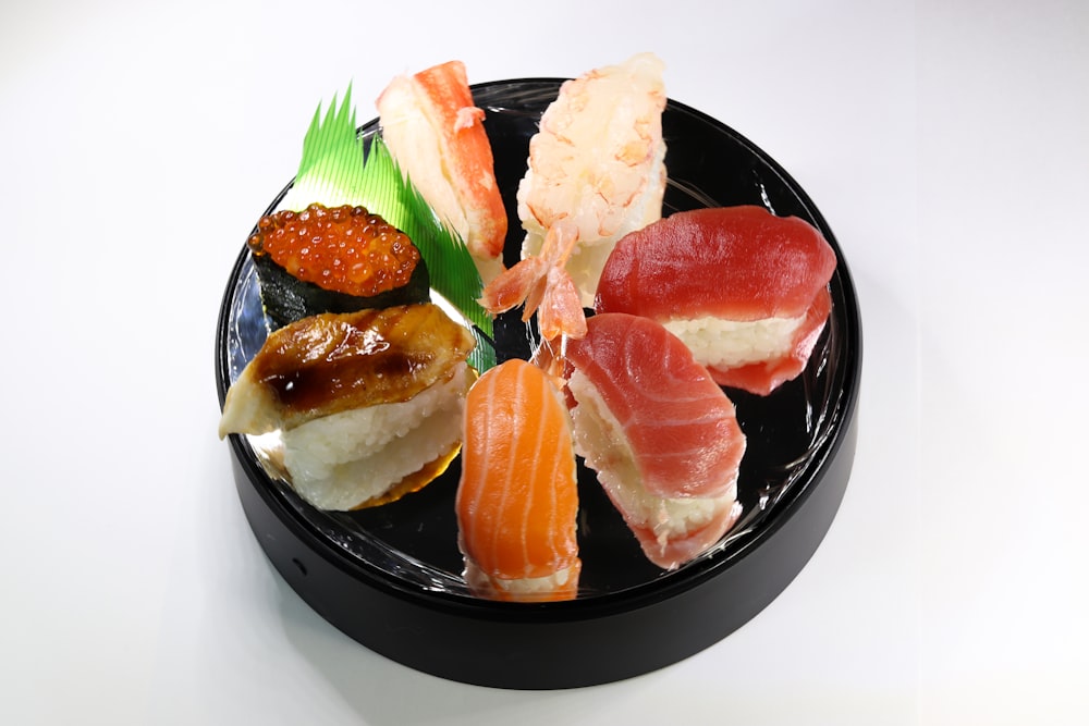 sliced meat with green leaf on black ceramic plate