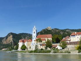 white and brown concrete building near body of water during daytime