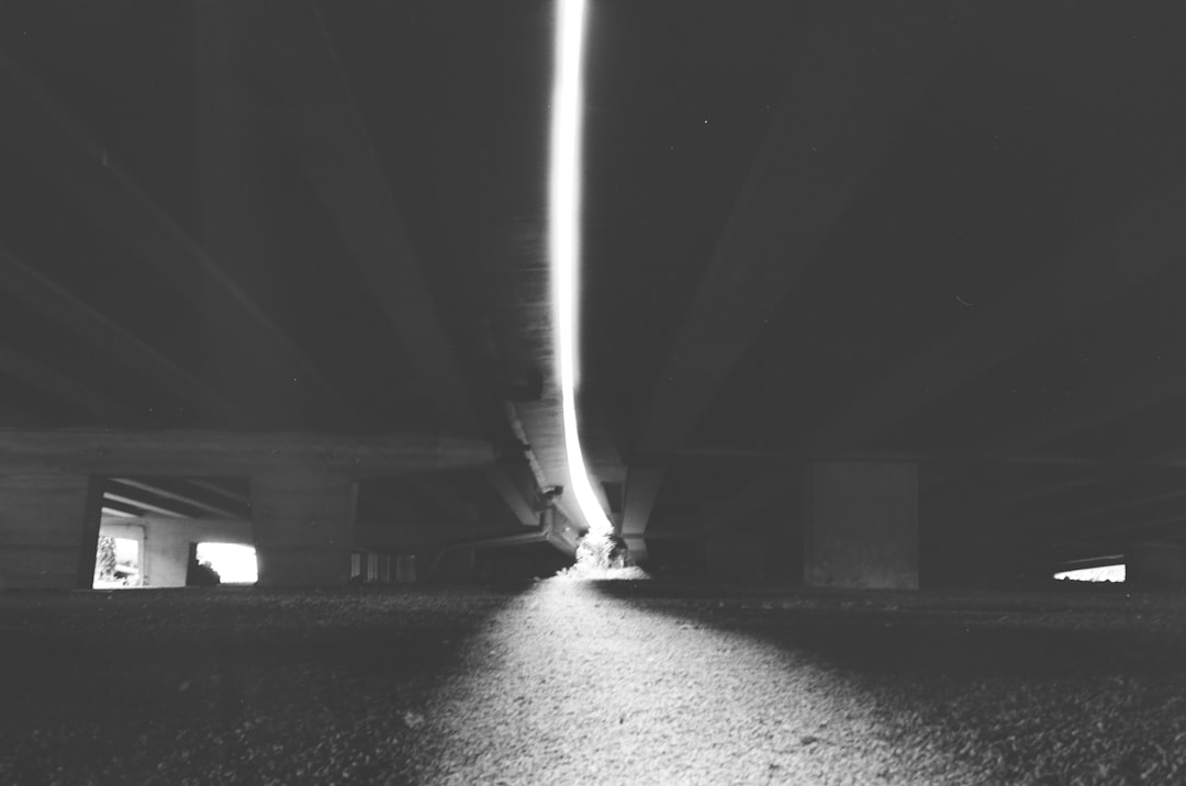 grayscale photo of tunnel with light