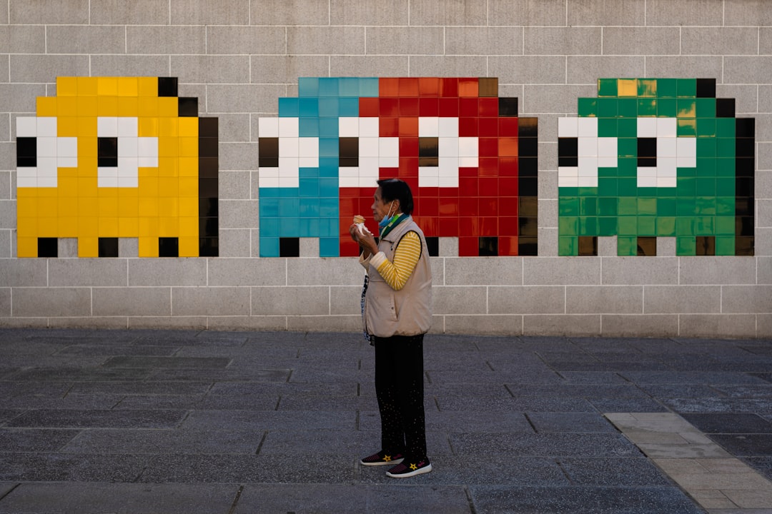 man in white jacket and black pants standing beside multi color wall