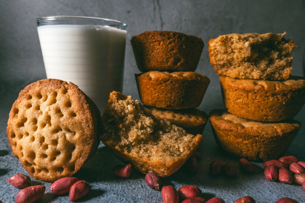 person holding white ceramic mug with brown cookies