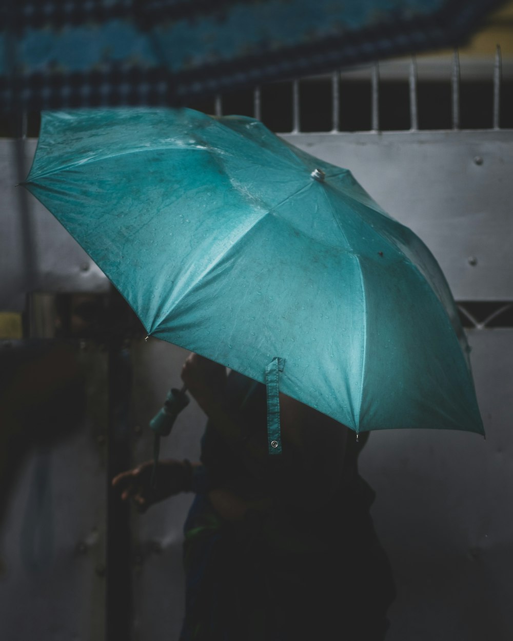 green umbrella on gray concrete floor