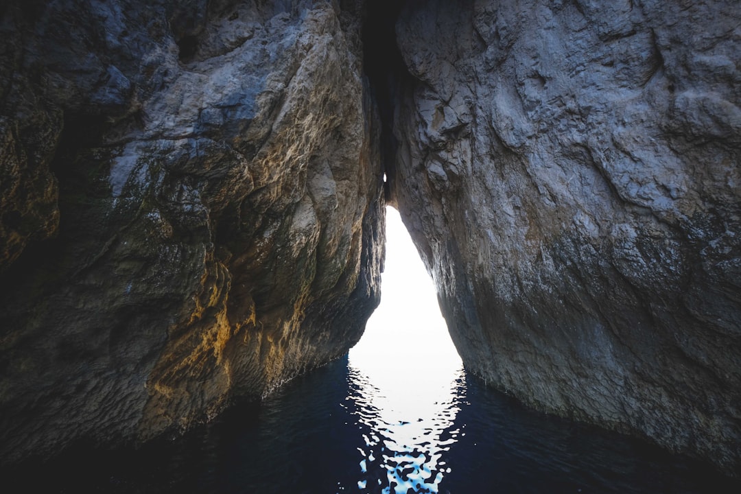 gray rock formation on body of water during daytime