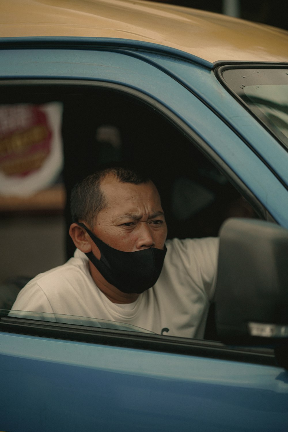 man in white shirt driving car