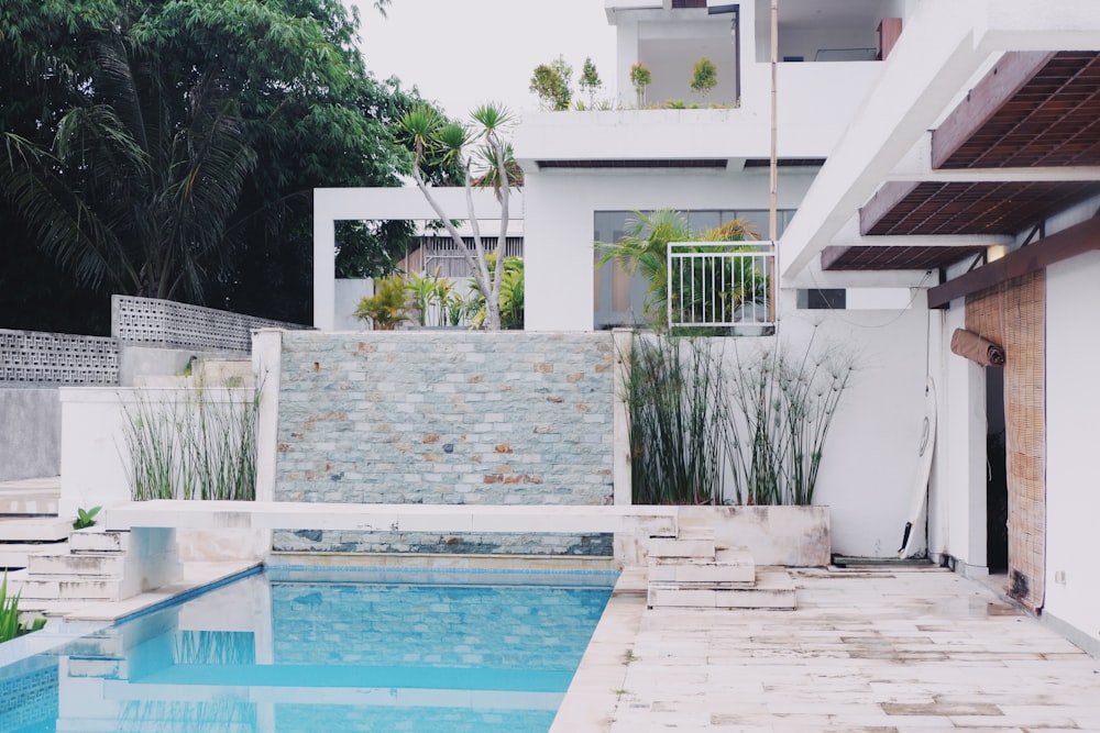 white concrete house near swimming pool during daytime