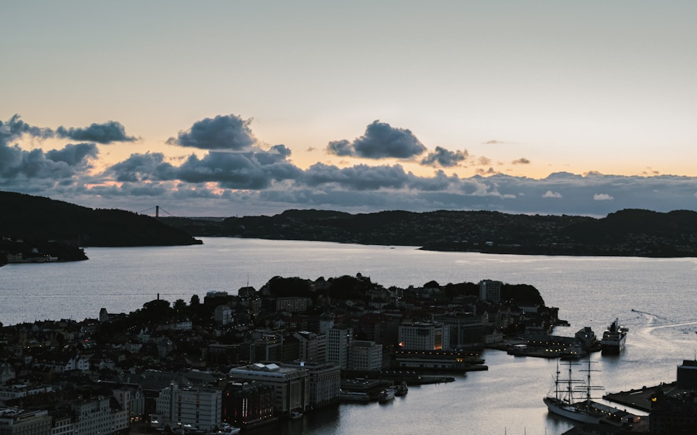 city skyline near body of water under cloudy sky during daytime