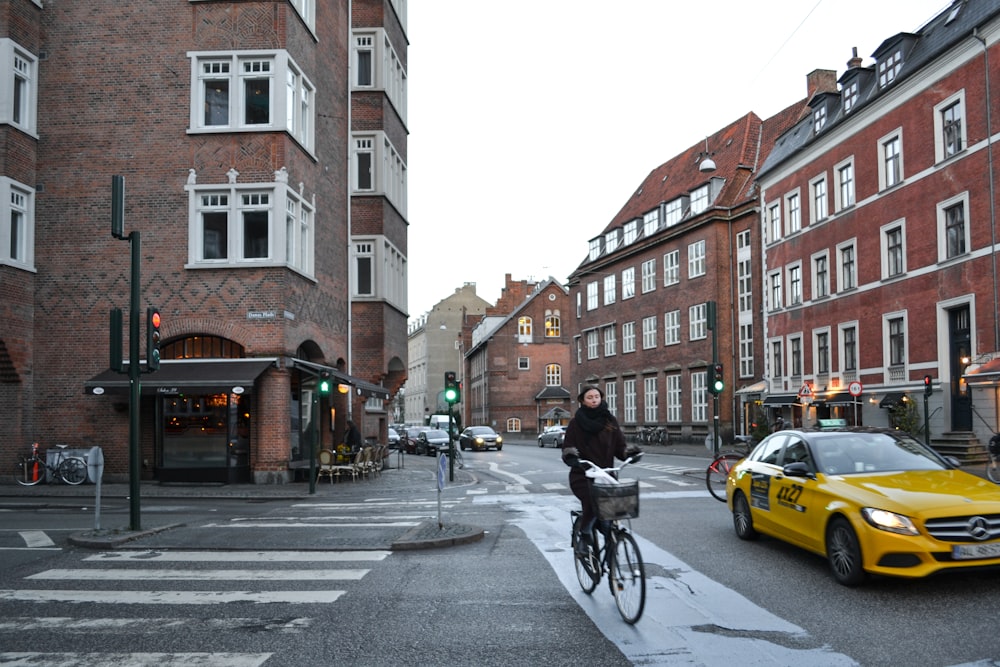 man in black jacket riding bicycle on road during daytime