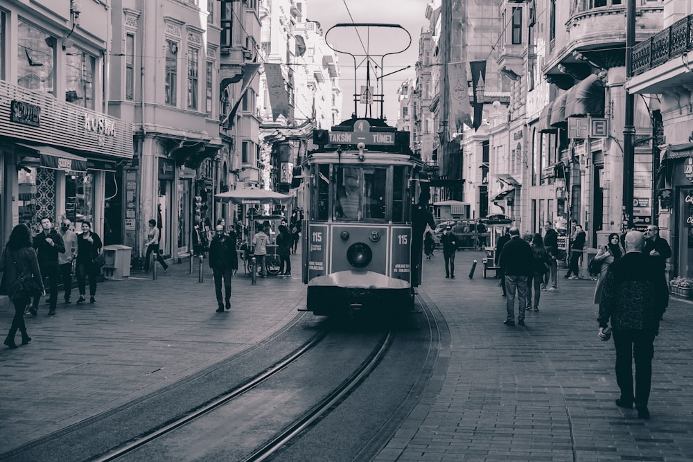 people walking on sidewalk near tram during daytime