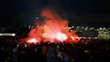 Flamengo fans celebrating passionately in a packed stadium during a night match.
