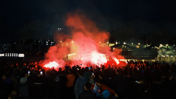 Energetic crowd celebrating with Flamengo flags waving during a night match.