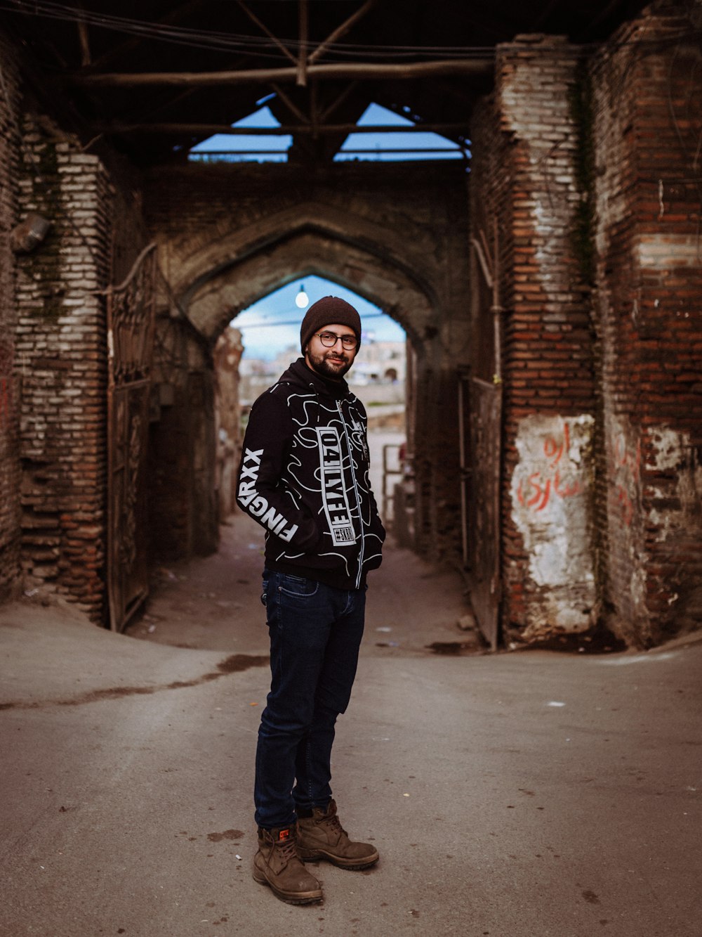 man in black and white hoodie standing in tunnel