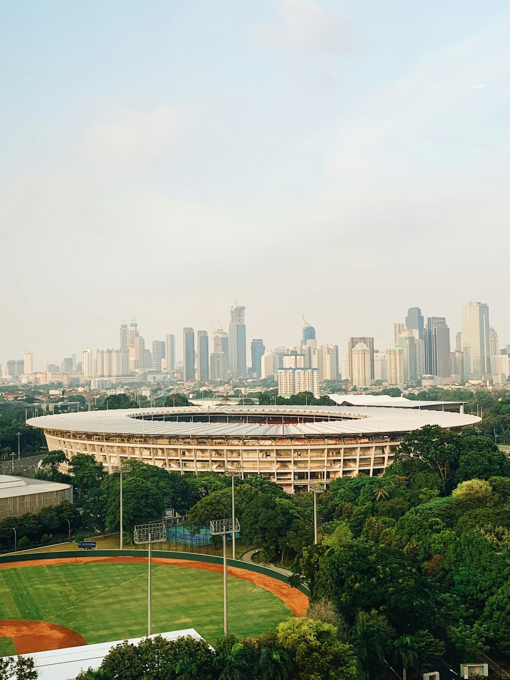 green and brown field surrounded with high rise buildings during daytime