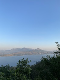 A serene landscape featuring mountains and a clear blue sky.