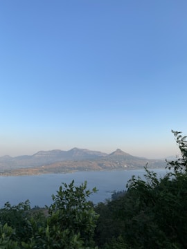 A serene landscape featuring mountains and a clear blue sky.