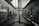 A symmetrical view of a server room or data center aisle with multiple server racks on both sides. The cabling is neatly arranged, and the environment appears dimly lit. The perspective converges at the center, creating a sense of depth.