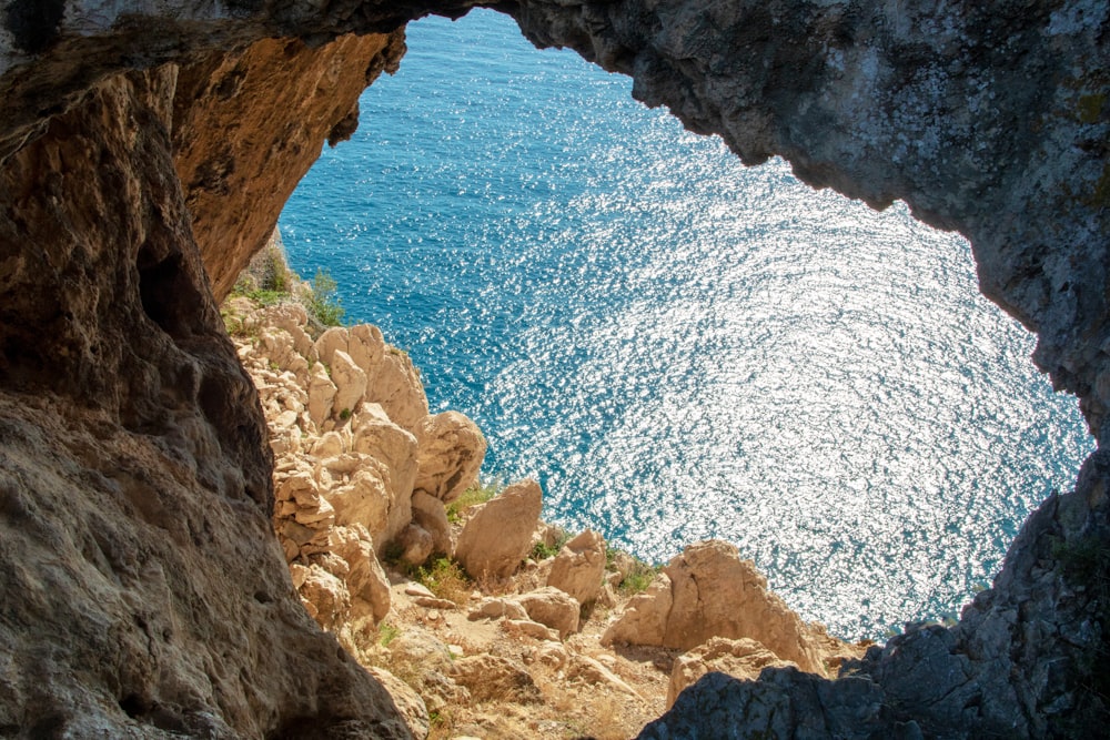 Montagna rocciosa marrone vicino al mare blu durante il giorno