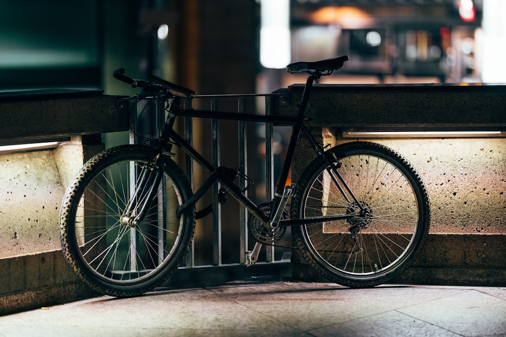 black bicycle parked beside black metal fence